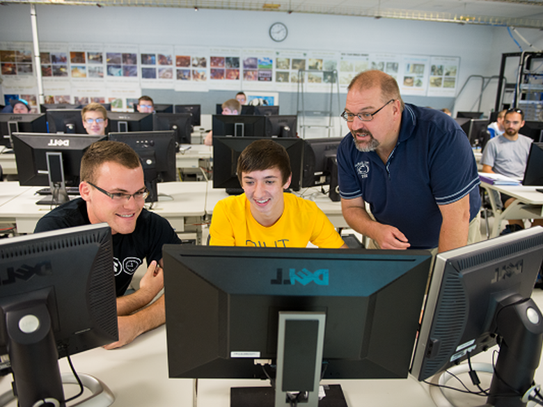 IST students working with instructor in technology class